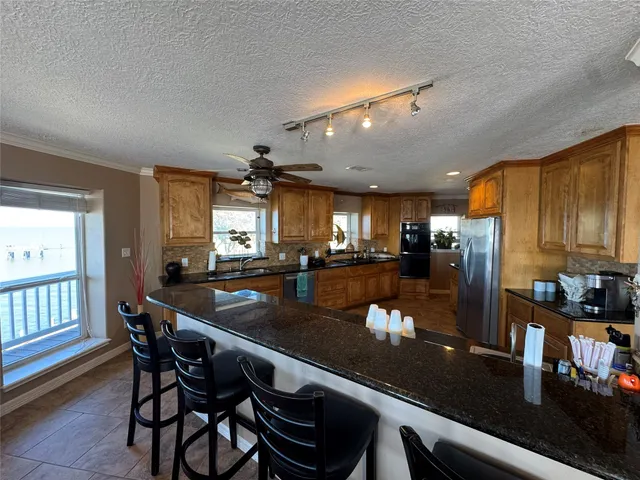 a kitchen with stainless steel appliances granite countertop a sink a stove and a refrigerator