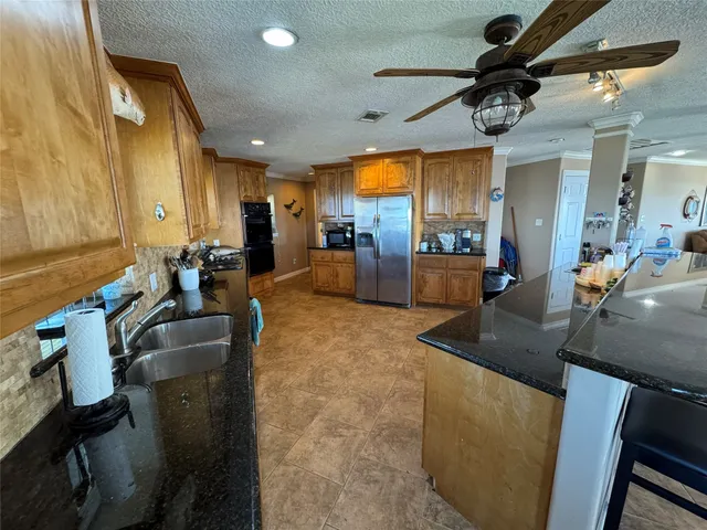a kitchen with stainless steel appliances a sink stove and refrigerator