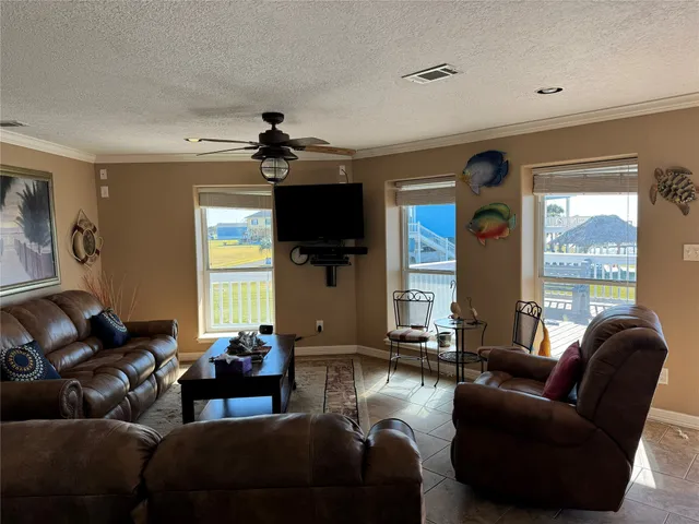 a living room with furniture ceiling fan and a window