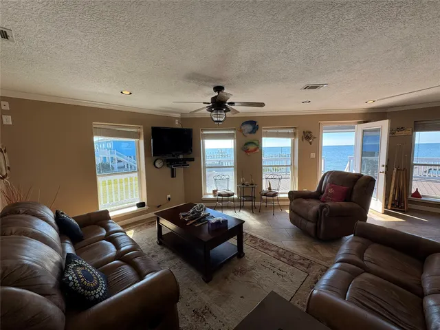 a living room with furniture ceiling fan and a window