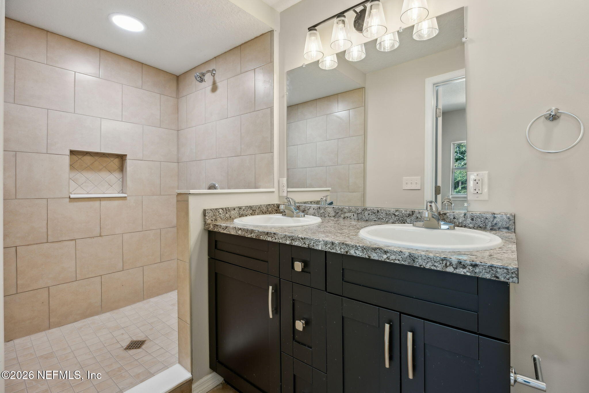 2562 Summit Street Jacksonville, FL 32204 - Photo 16 of 20 a bathroom with a granite countertop sink a mirror and a shower