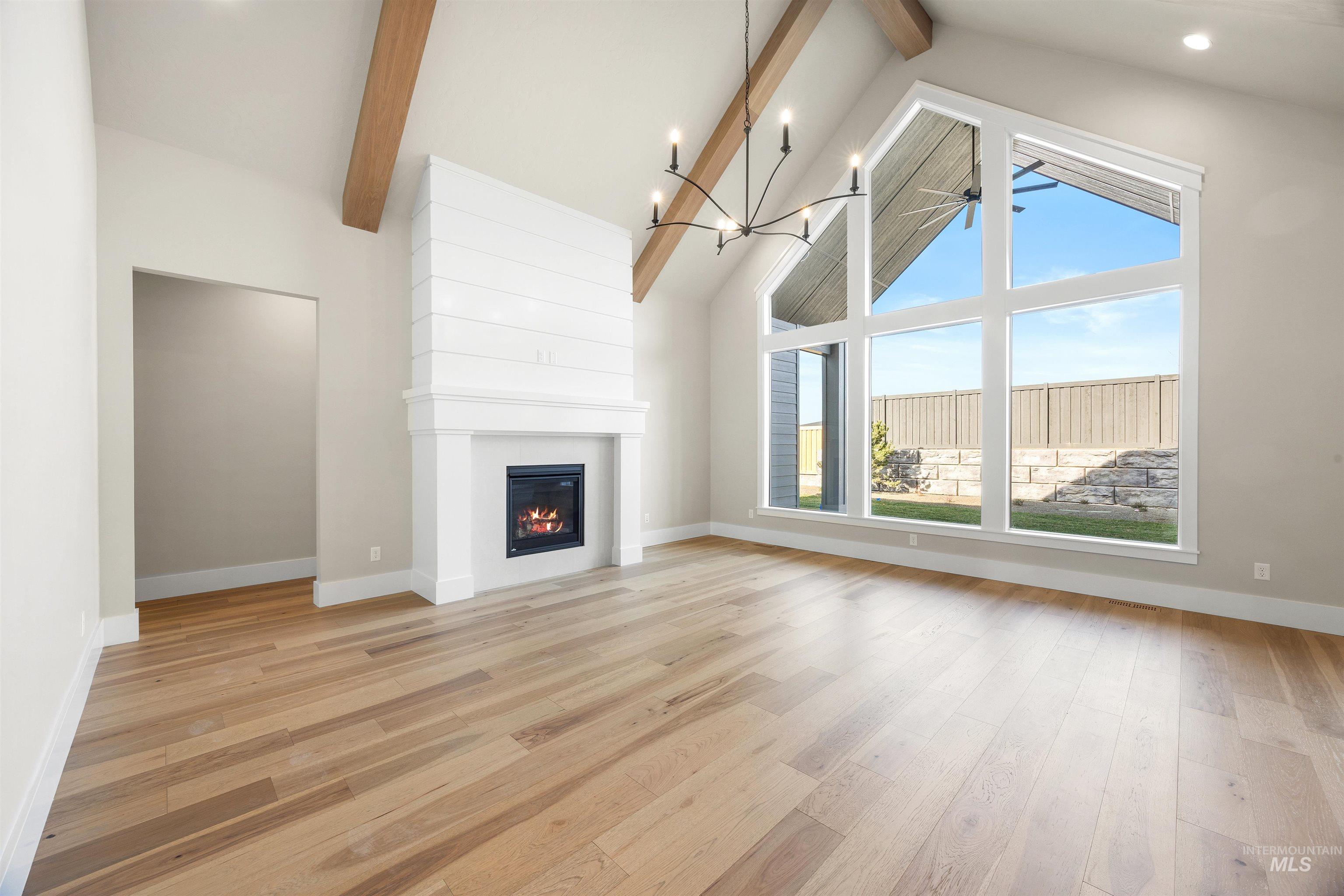 1126 East Crescendo Street Meridian, ID 83642 - Photo 12 of 48 Unfurnished living room with light wood-style flooring, suspended lighting, and a large fireplace