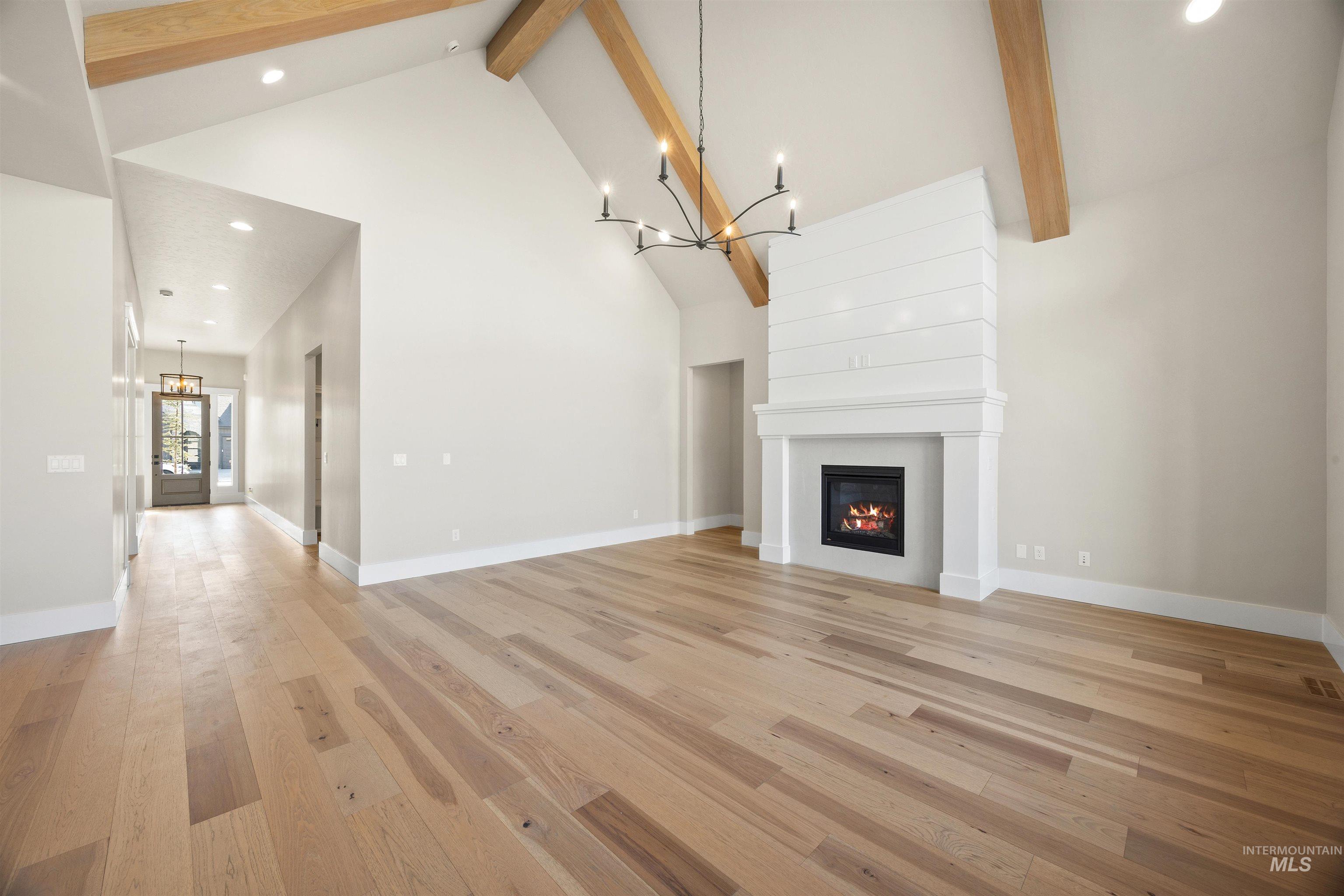 1126 East Crescendo Street Meridian, ID 83642 - Photo 14 of 48 Unfurnished living room with hanging lights, light wood-type flooring, and a large fireplace