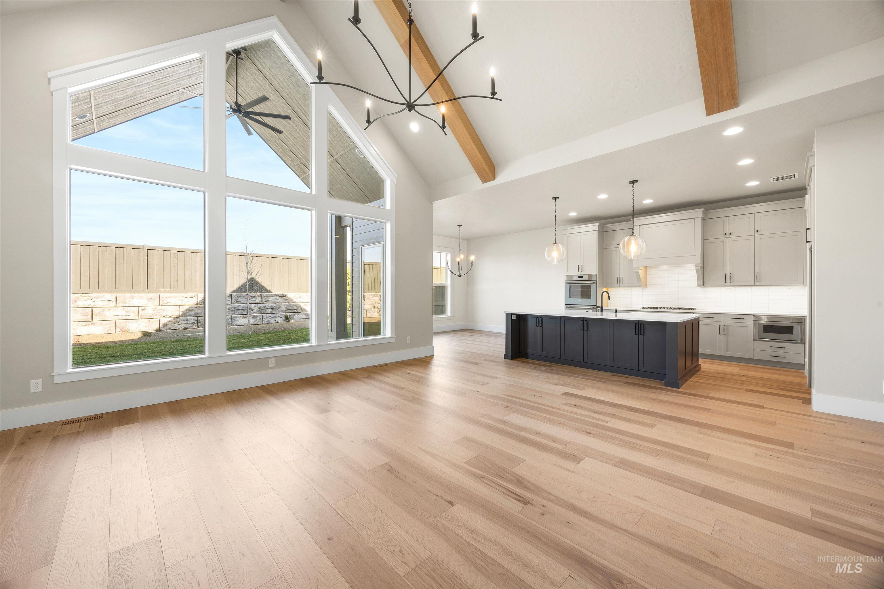 1126 East Crescendo Street Meridian, ID 83642 - Photo 47 of 48 Kitchen with a chandelier, dual tone cabinets, open floor plan, light countertops, and a kitchen island with sink