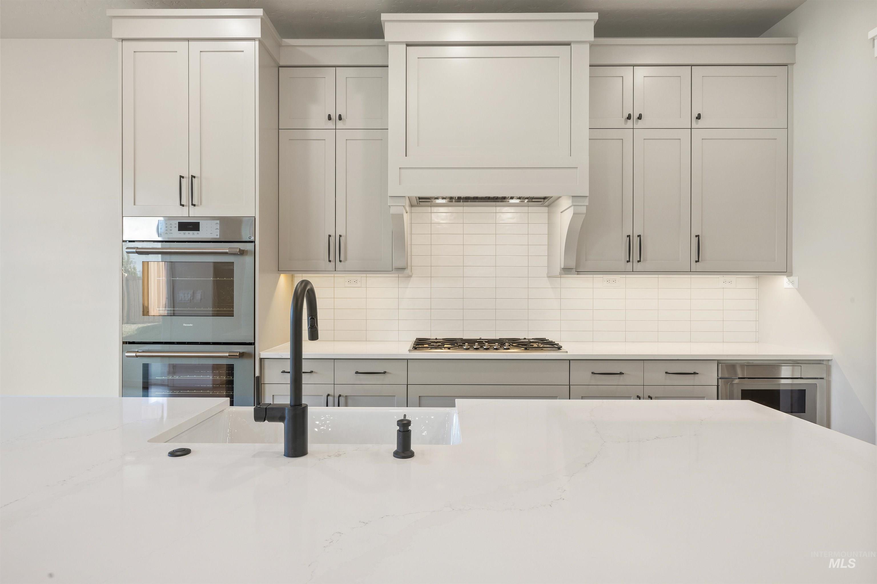 1126 East Crescendo Street Meridian, ID 83642 - Photo 21 of 48 Kitchen featuring stainless steel appliances, light stone countertops, and decorative backsplash