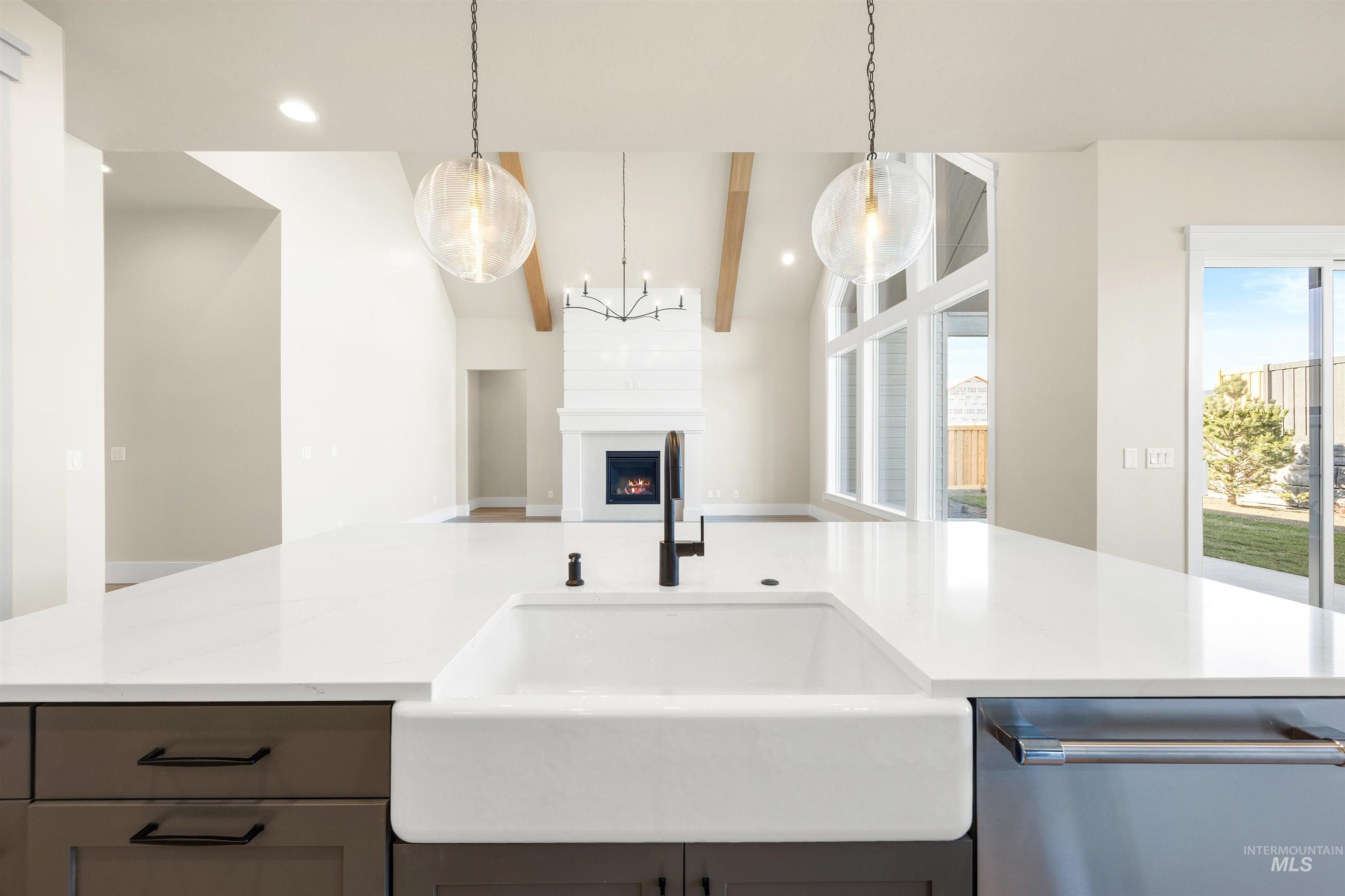 1126 East Crescendo Street Meridian, ID 83642 - Photo 27 of 48 Kitchen with a fireplace, dishwasher, hanging light fixtures, light stone counters, and a center island with sink