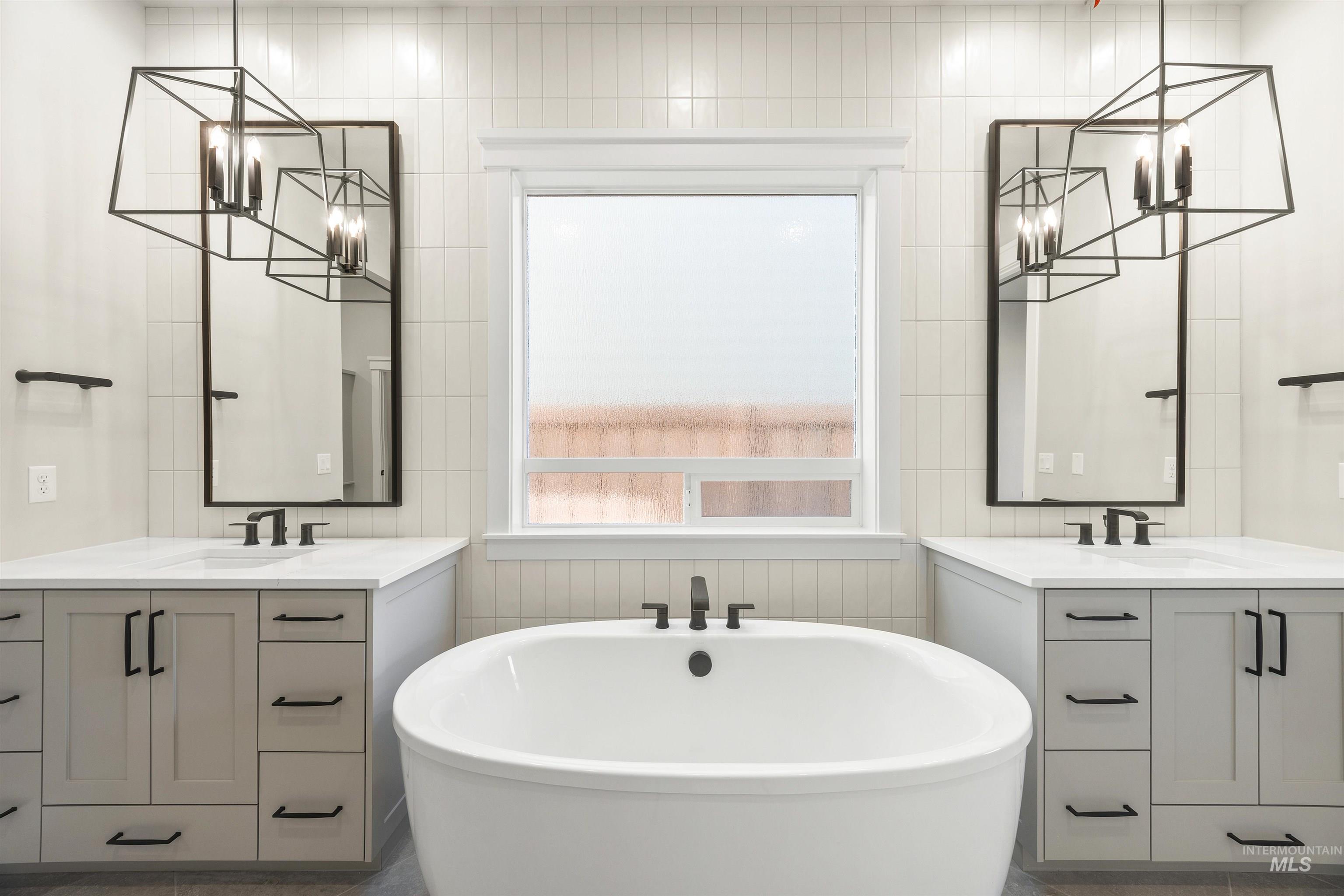 1126 East Crescendo Street Meridian, ID 83642 - Photo 32 of 48 Full bath with two vanities, a freestanding tub, and suspended lighting
