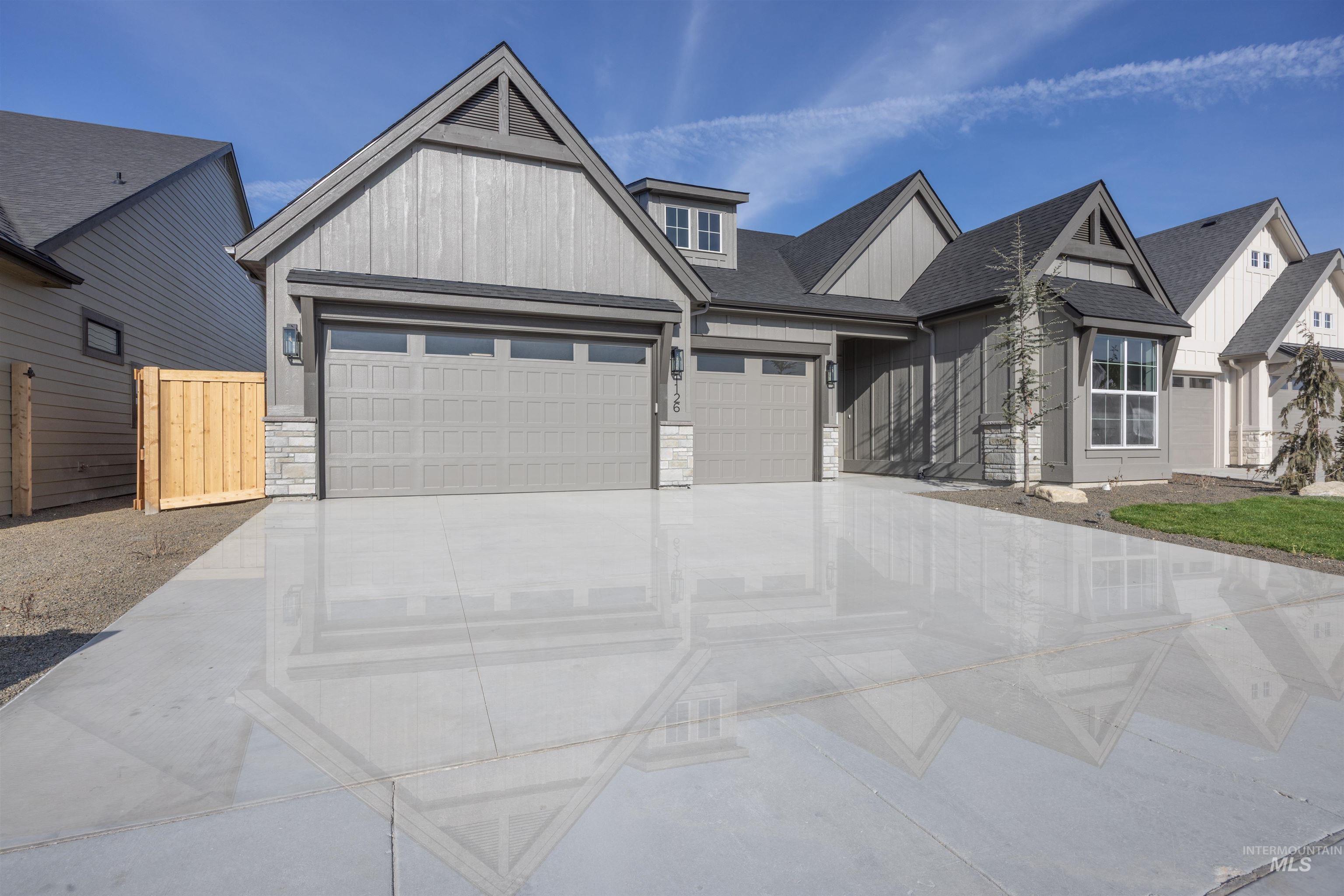 1126 East Crescendo Street Meridian, ID 83642 - Photo 45 of 48 Modern inspired farmhouse featuring stone siding, concrete driveway, an attached garage, a shingled roof, and board and batten siding