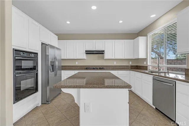 a kitchen with stainless steel appliances granite countertop a refrigerator and a sink