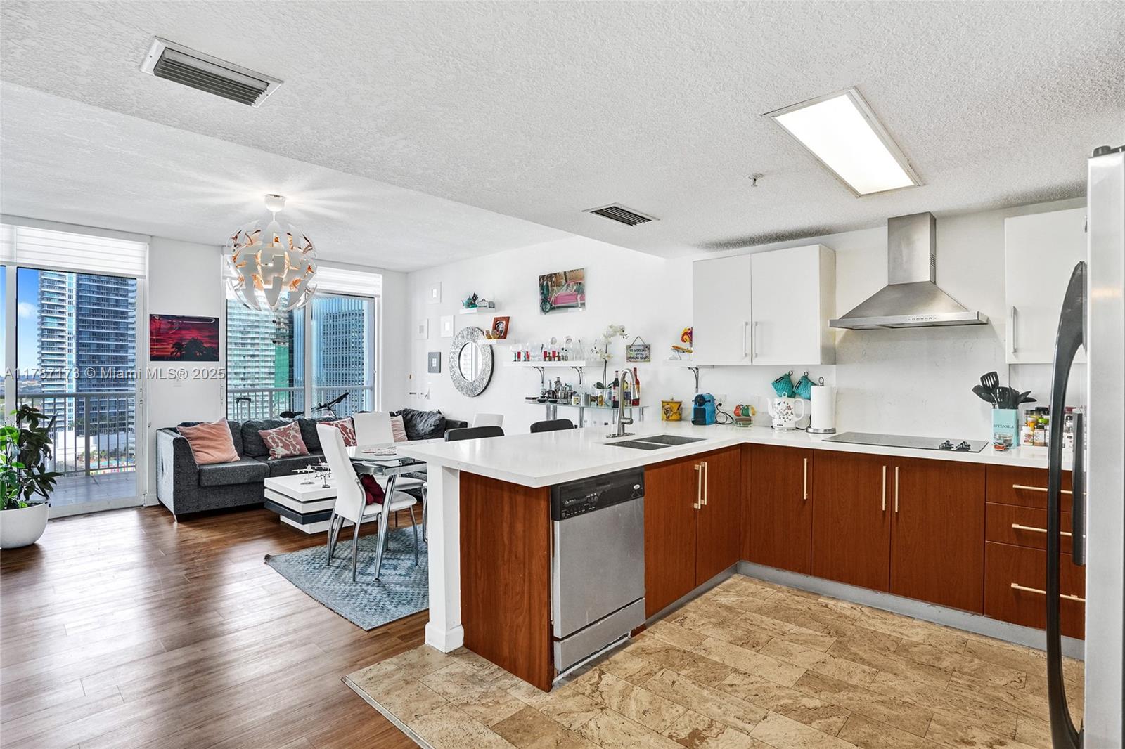 170 Southeast 14th Street, Unit 2907 Miami, FL 33131 - Photo 19 of 30 a kitchen with stainless steel appliances granite countertop a sink dishwasher stove and wooden cabinets
