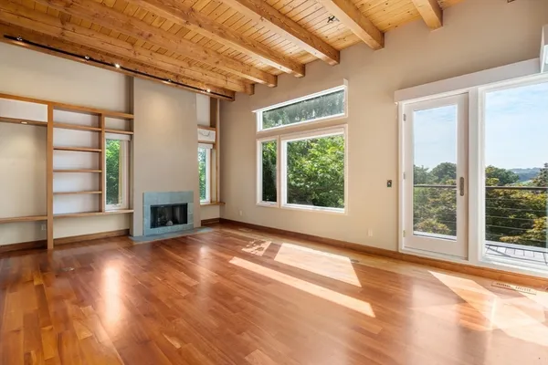 a view of an empty room with a fireplace and a window