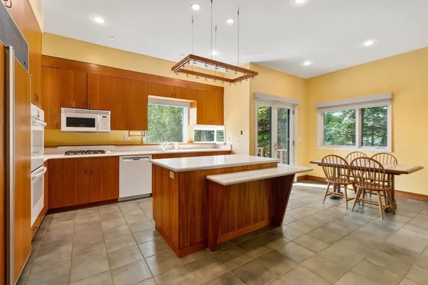 a large kitchen with stainless steel appliances a sink and cabinets