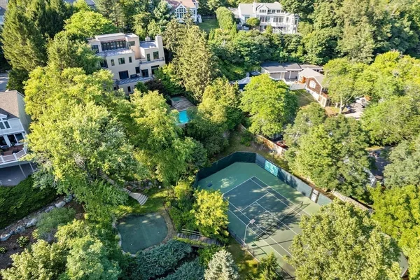 an aerial view of residential house with outdoor space and trees all around