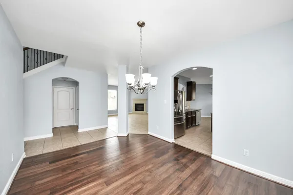a view of a room with wooden floor staircase and a kitchen
