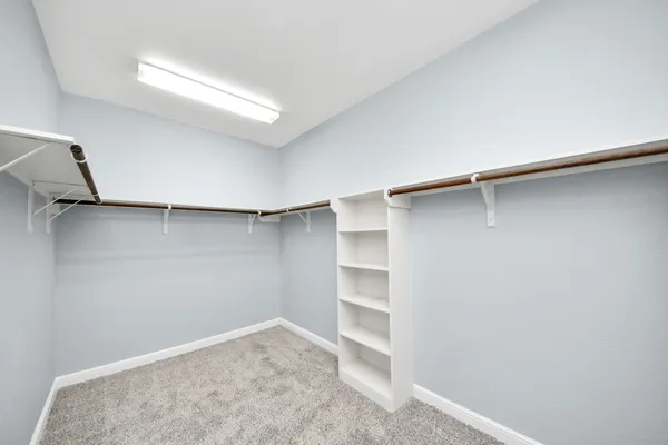 a view of walk in closet with empty racks