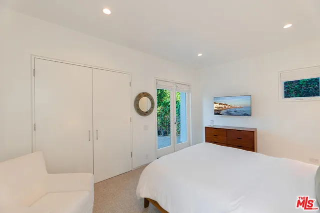 a bedroom with a bed and a painting on the wall