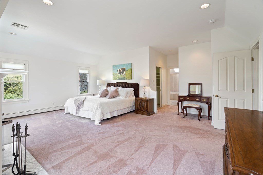 23 Louis Drive Wellesley, MA 02481 - Photo 23 of 42 a spacious bedroom with a bed and a table in it