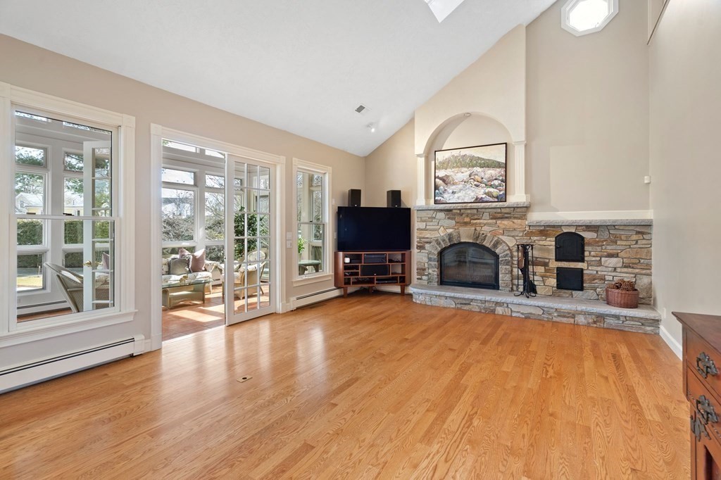 23 Louis Drive Wellesley, MA 02481 - Photo 10 of 42 a view of a livingroom with a fireplace a flat screen tv and windows