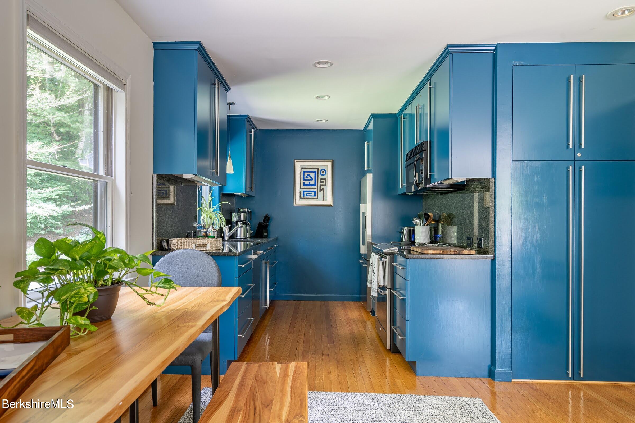 91 Brush Hill Road Great Barrington, MA 01230 - Photo 14 of 40 a kitchen with stainless steel appliances granite countertop a refrigerator a sink dishwasher a stove and a dining table with wooden floor