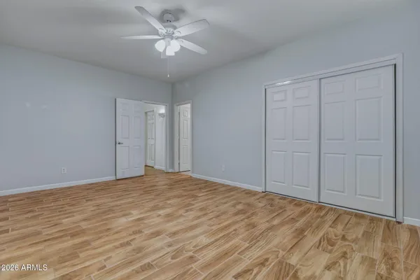 a view of an empty room with chandelier fan