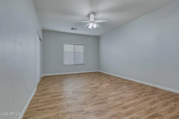 an empty room with windows and fan