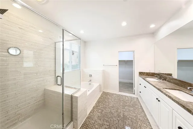 a bathroom with a granite countertop bathtub shower sink and mirror
