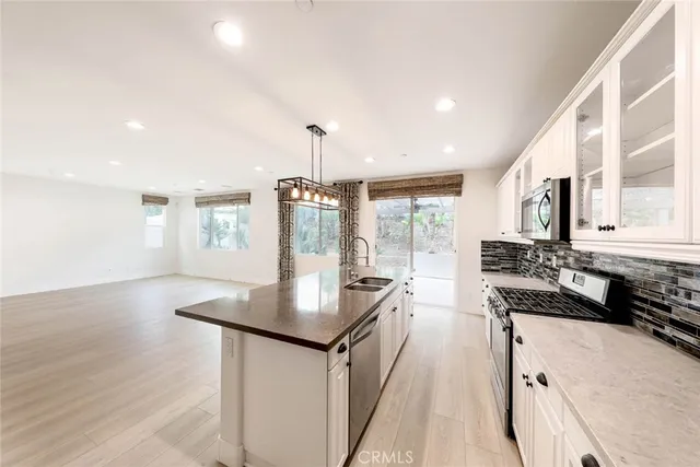 a kitchen with stainless steel appliances granite countertop a sink a stove and a wooden floors