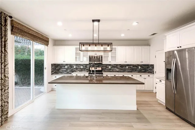 a kitchen with kitchen island stainless steel appliances a sink and a window