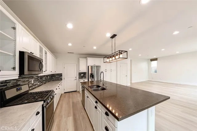 a kitchen with stainless steel appliances granite countertop a sink a stove top oven a counter space and cabinets
