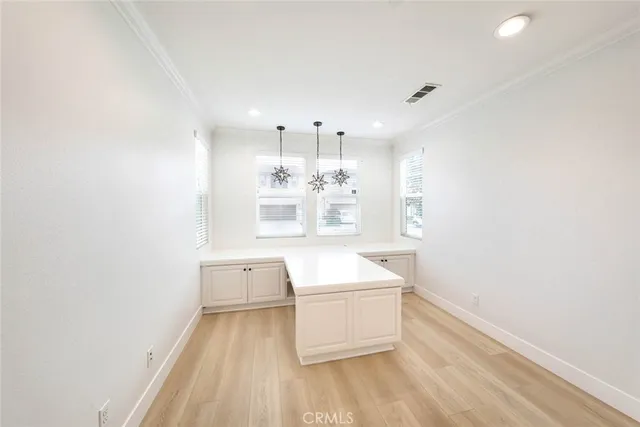 a room with stainless steel appliances wooden floor and white walls