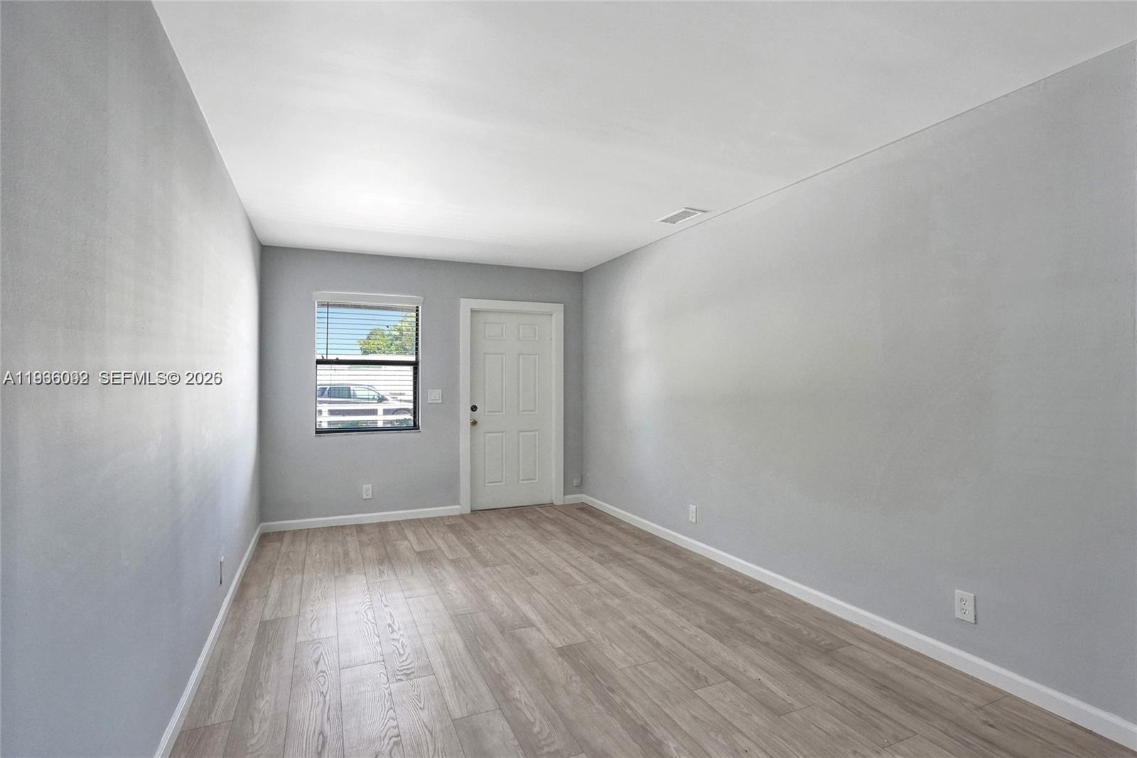 1200 West 31st Street, Unit B Riviera Beach, FL 33404 - Photo 11 of 20 wooden floor in an empty room with a window