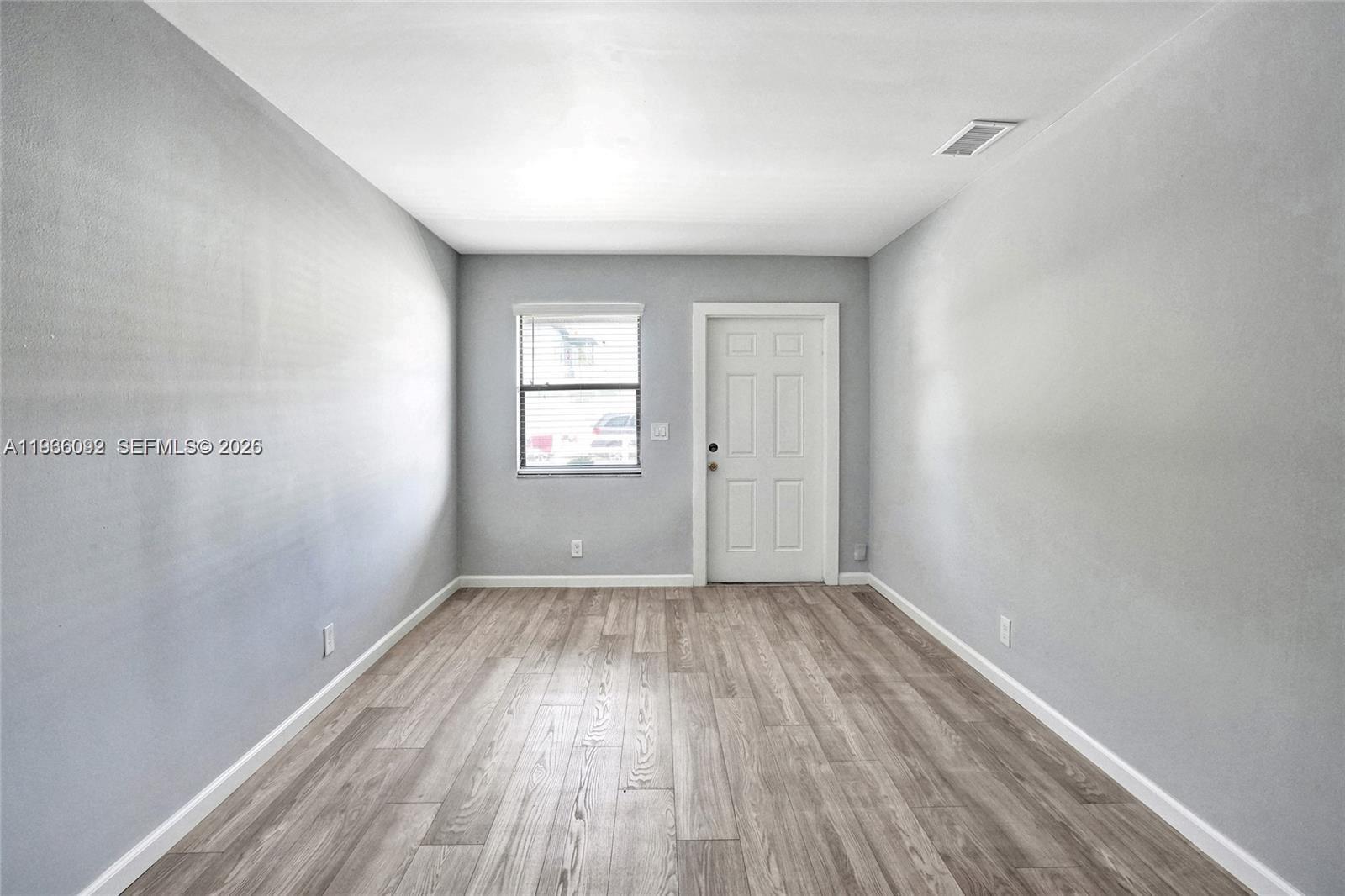 1200 West 31st Street, Unit B Riviera Beach, FL 33404 - Photo 13 of 20 an empty room with wooden floor and windows