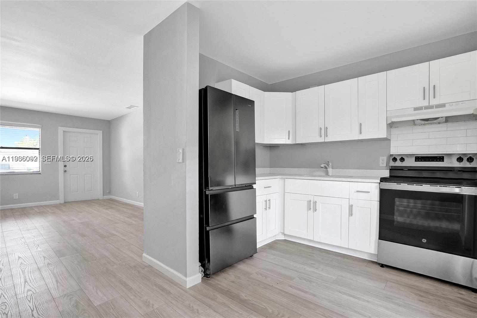 1200 West 31st Street, Unit B Riviera Beach, FL 33404 - Photo 14 of 20 a kitchen with a refrigerator stove and white cabinets