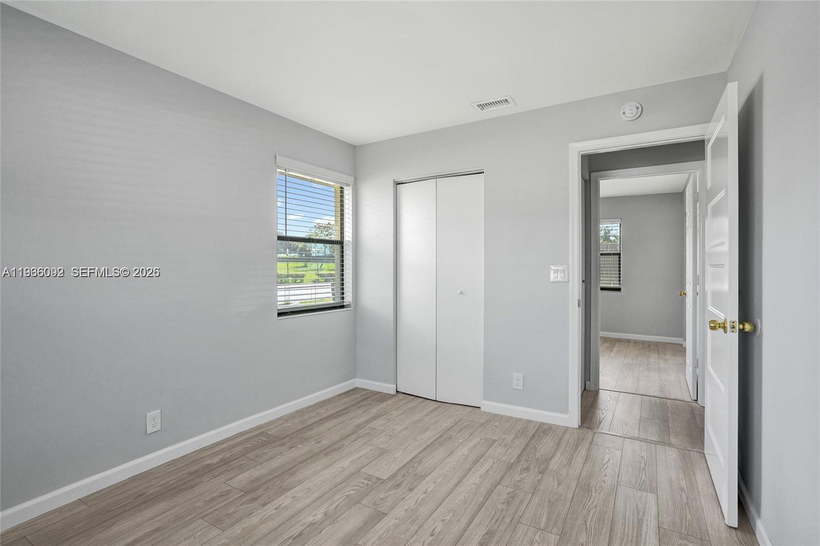 1200 West 31st Street, Unit B Riviera Beach, FL 33404 - Photo 5 of 20 an empty room with wooden floor and windows