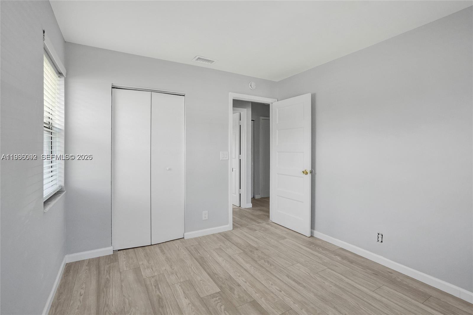 1200 West 31st Street, Unit B Riviera Beach, FL 33404 - Photo 6 of 20 a view of an empty room with wooden floor and closet area