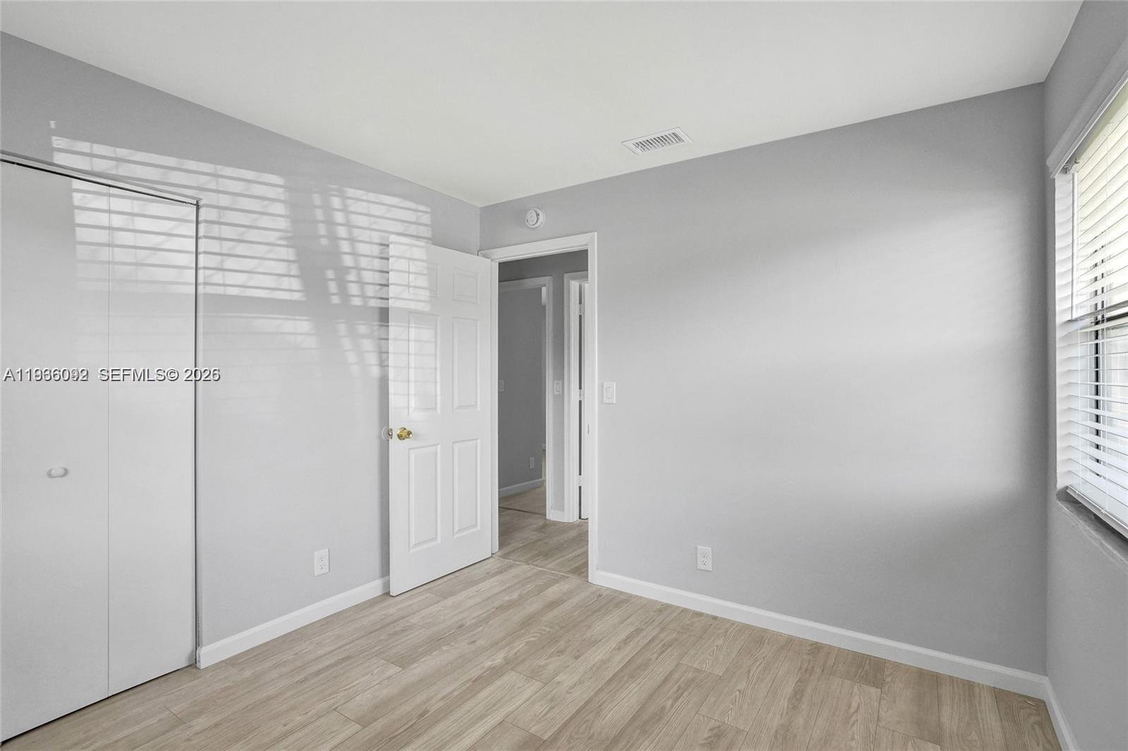 1200 West 31st Street, Unit B Riviera Beach, FL 33404 - Photo 8 of 20 a view of an empty room with wooden floor and a window
