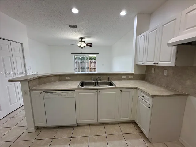 a kitchen with a sink window and cabinets