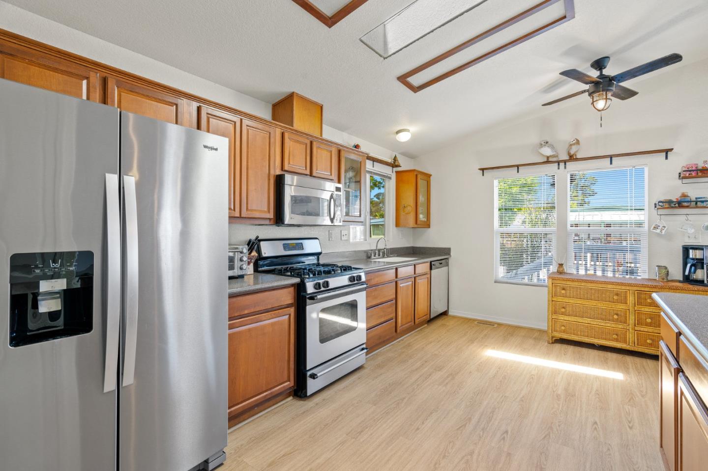 100 North Rodeo Gulch Road, Unit 31 Soquel, CA 95073 - Photo 13 of 38 a kitchen with stainless steel appliances granite countertop a refrigerator a stove top oven a sink with wooden floor and cabinets