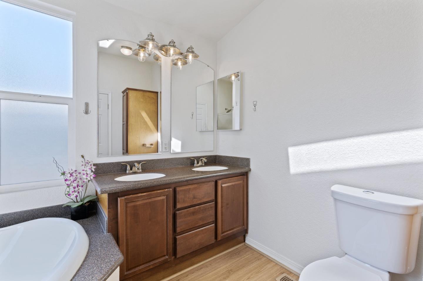 100 North Rodeo Gulch Road, Unit 31 Soquel, CA 95073 - Photo 21 of 38 a bathroom with a granite countertop sink a toilet and mirror