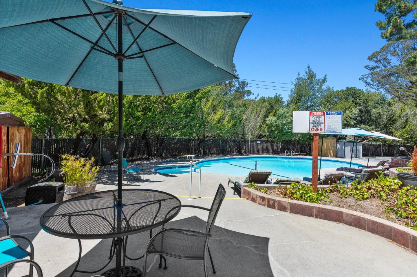 100 North Rodeo Gulch Road, Unit 31 Soquel, CA 95073 - Photo 37 of 38 a patio with a table and chairs under an umbrella