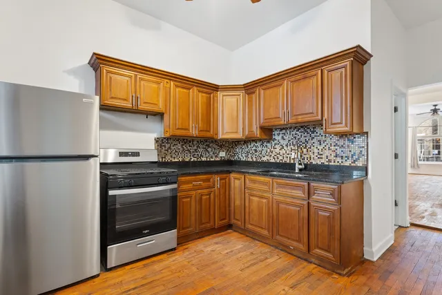 a kitchen with stainless steel appliances granite countertop a stove a sink and a refrigerator