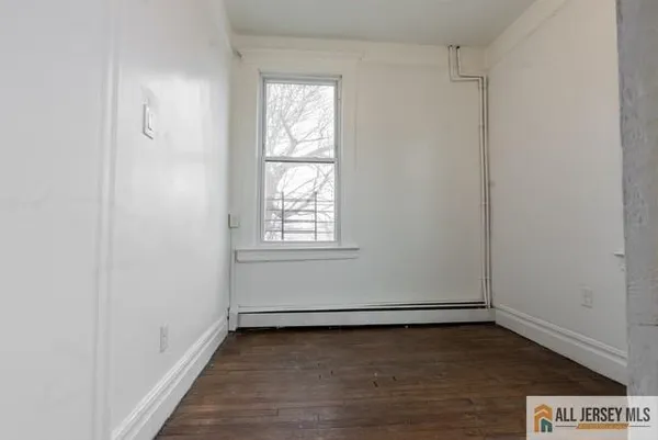 a view of a room with wooden floor and window