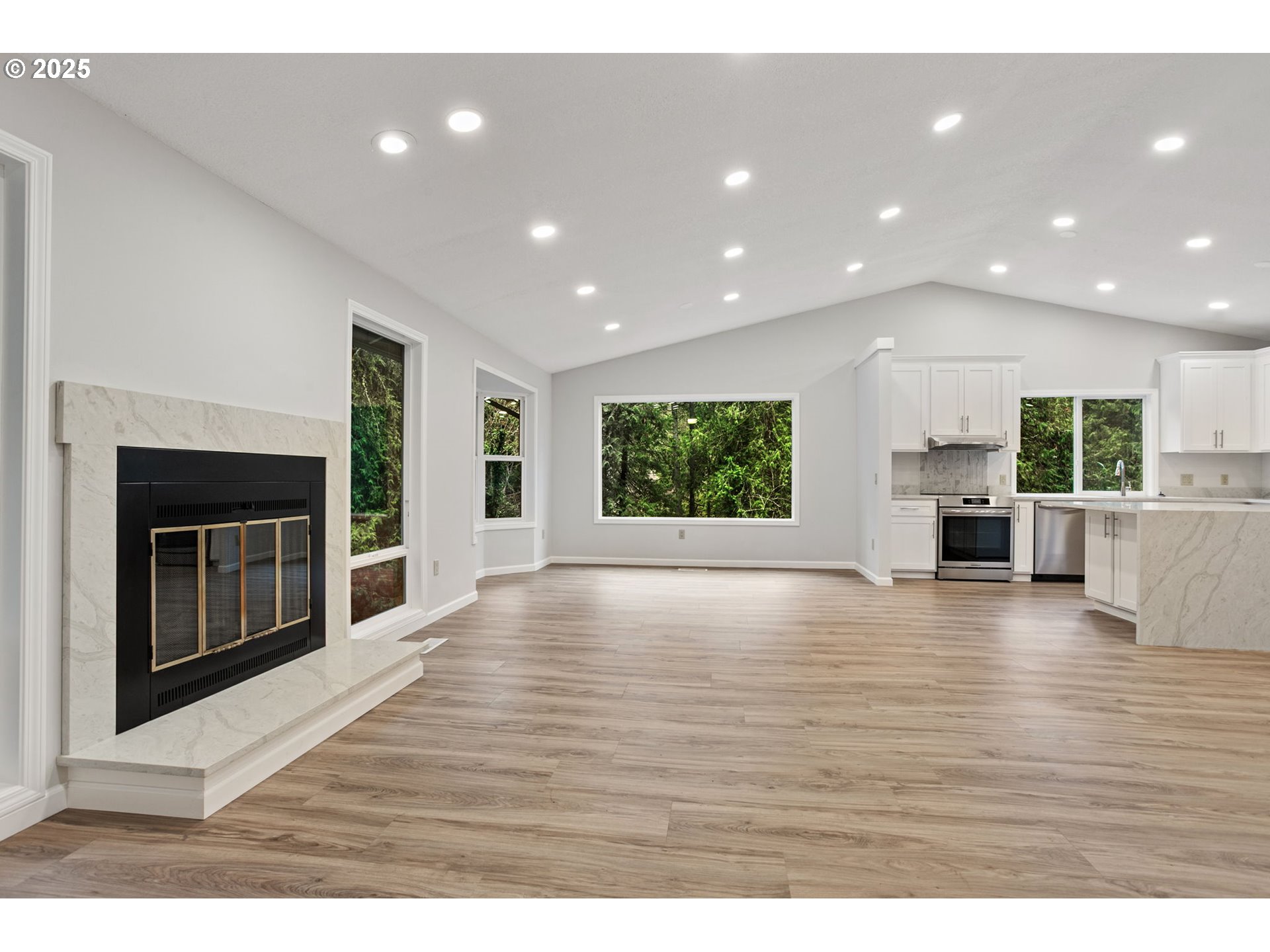 6647 Southeast 122nd Avenue Portland, OR 97266 - Photo 17 of 48 a view of an empty room with wooden floor and a kitchen