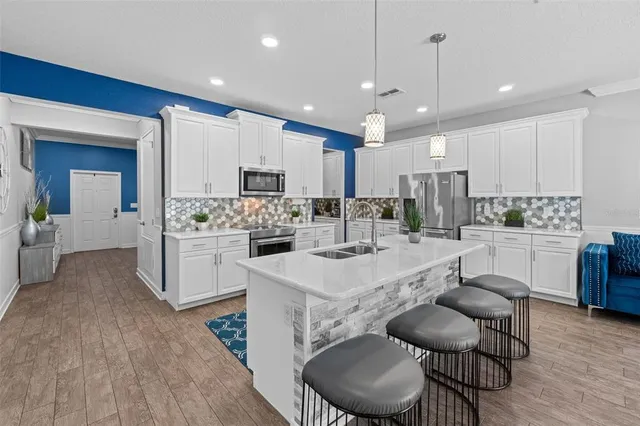 a kitchen with kitchen island granite countertop a white cabinets and chairs