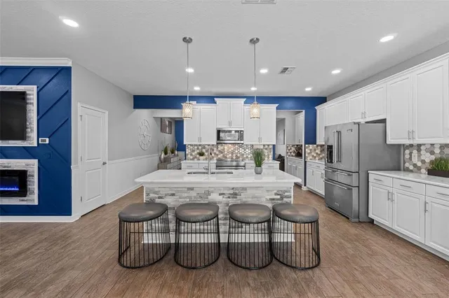 a kitchen with white cabinets and stainless steel appliances