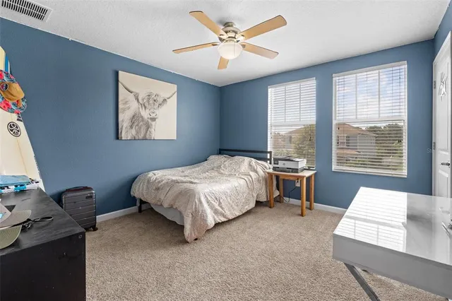 a bedroom with a bed window and a flat screen tv