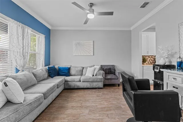 a living room with furniture ceiling fan and a window