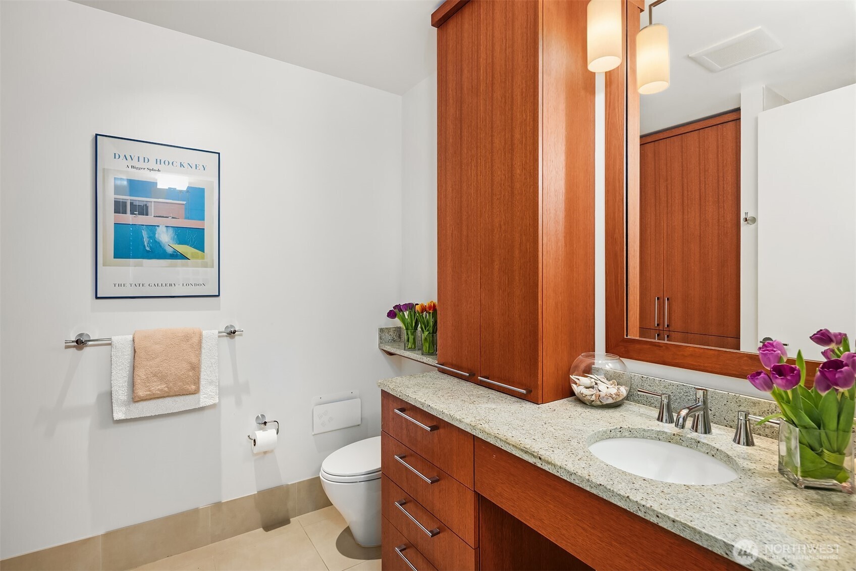 1521 2nd Avenue, Unit 1001 Seattle, WA 98101 - Photo 21 of 37 a bathroom with a granite countertop sink a toilet and mirror