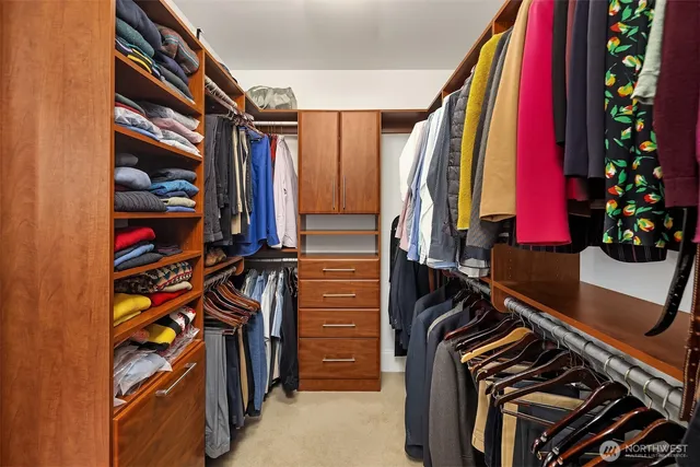 a view of walk in closet with clothes and shoes