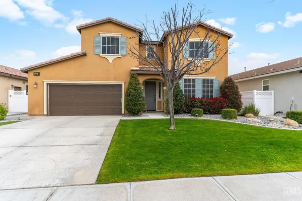 a front view of a house with a garden and yard